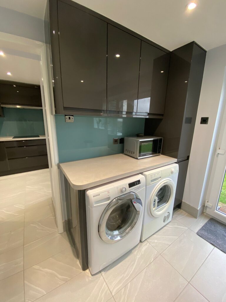 Utility housing for the washer and dryer in this fitted kitchen by Dymchurch Improvements.